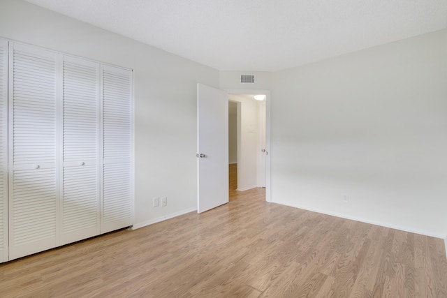 unfurnished bedroom featuring a closet and light wood-type flooring