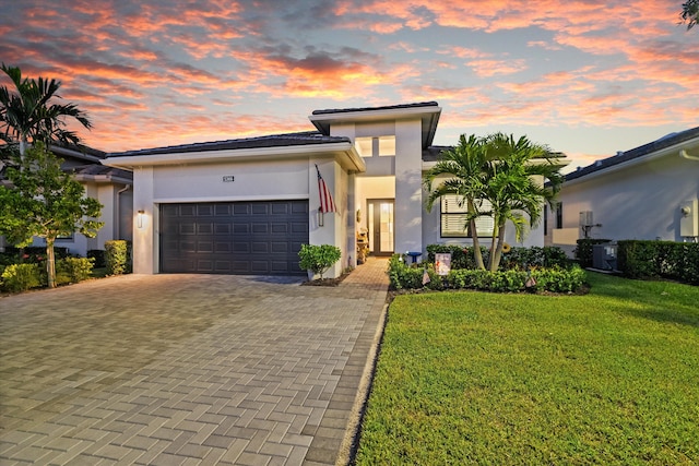 view of front facade with a lawn, cooling unit, a garage, and french doors