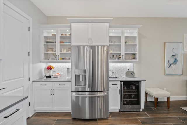 bar featuring stainless steel fridge, tasteful backsplash, white cabinetry, and beverage cooler