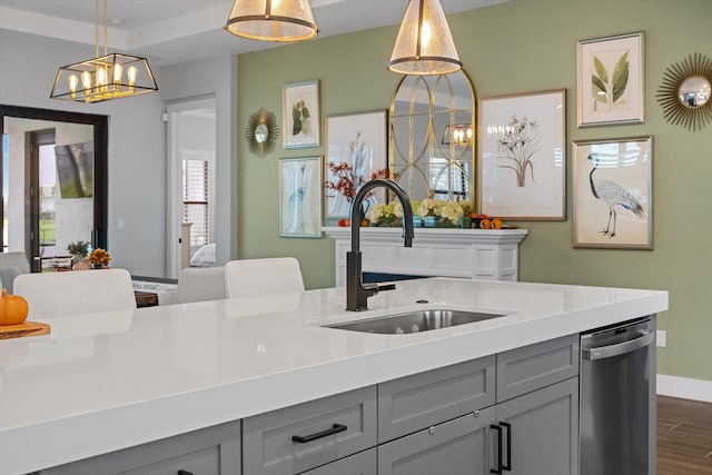 kitchen with gray cabinets, sink, stainless steel dishwasher, and decorative light fixtures