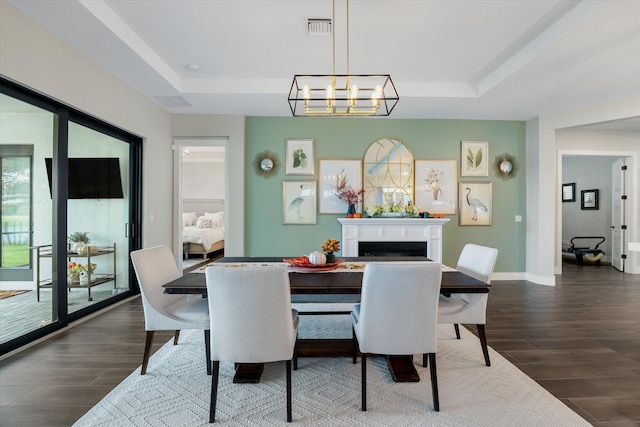 dining area featuring a raised ceiling and a chandelier