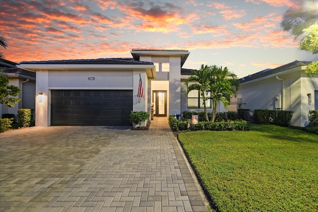 view of front of house featuring a garage and a yard