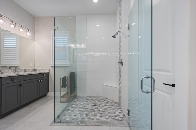 bathroom with tile patterned floors, vanity, and walk in shower