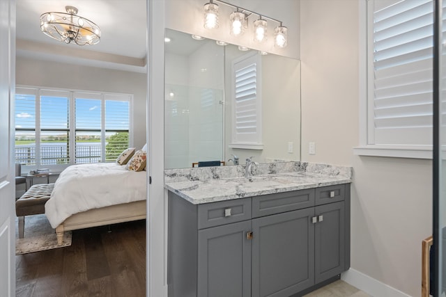 bathroom with a shower, wood-type flooring, vanity, and an inviting chandelier