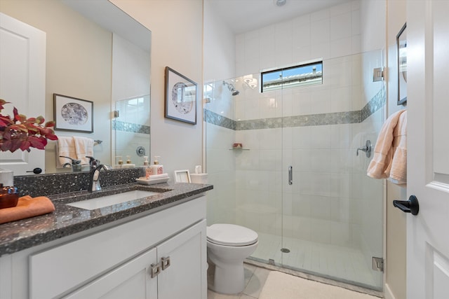 bathroom with tile patterned flooring, vanity, a shower with shower door, and toilet