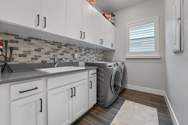 clothes washing area featuring cabinets, independent washer and dryer, and sink