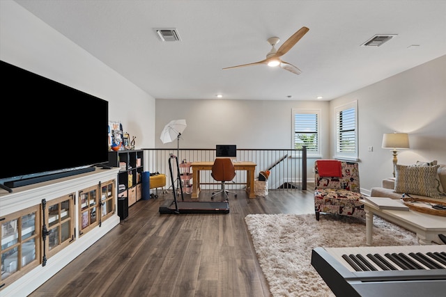 sitting room with ceiling fan and dark wood-type flooring