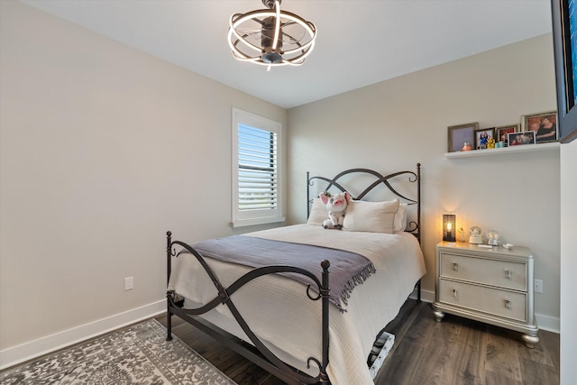 bedroom featuring dark hardwood / wood-style flooring and a notable chandelier