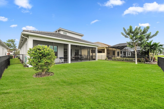 rear view of property with a lawn, a sunroom, and a lanai