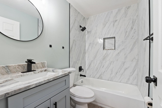 full bathroom featuring tiled shower / bath combo, toilet, and vanity