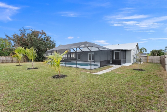 rear view of house featuring a lanai, a fenced in pool, and a yard