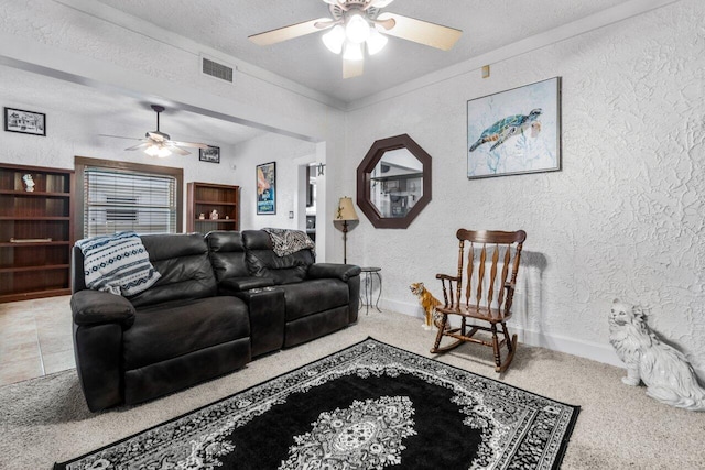 carpeted living room featuring a textured ceiling and ceiling fan