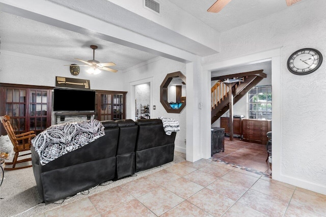 tiled living room with a textured ceiling and ceiling fan