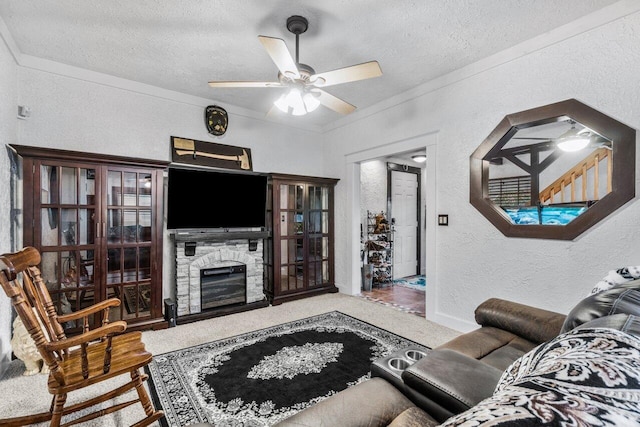 living room with carpet, ceiling fan, a stone fireplace, and a textured ceiling