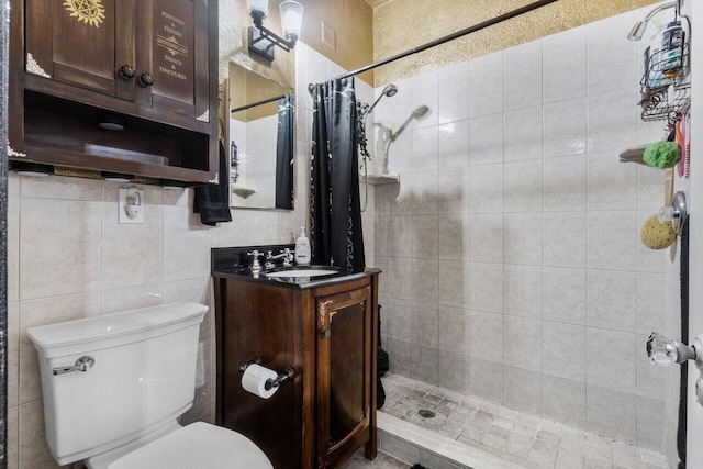 bathroom with a shower with curtain, vanity, tile walls, and toilet