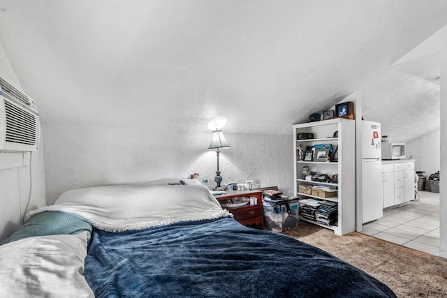 carpeted bedroom featuring white refrigerator and vaulted ceiling