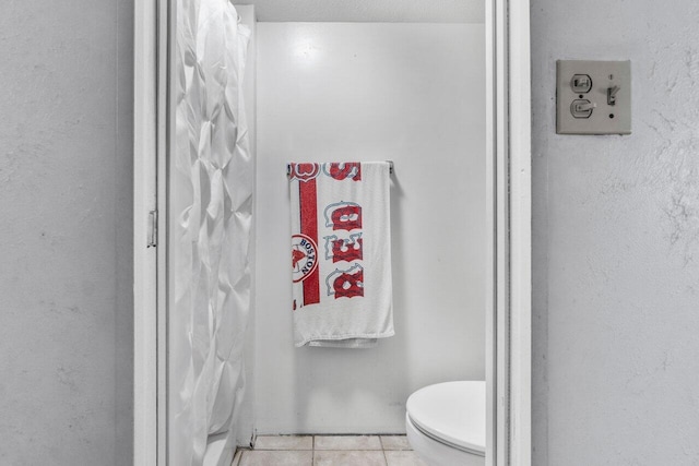 bathroom with toilet and tile patterned floors