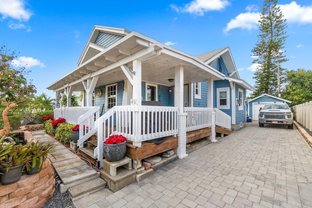 view of front of property featuring an outbuilding, a garage, and covered porch