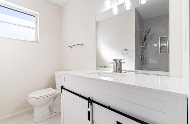 bathroom with vanity, toilet, and tiled shower