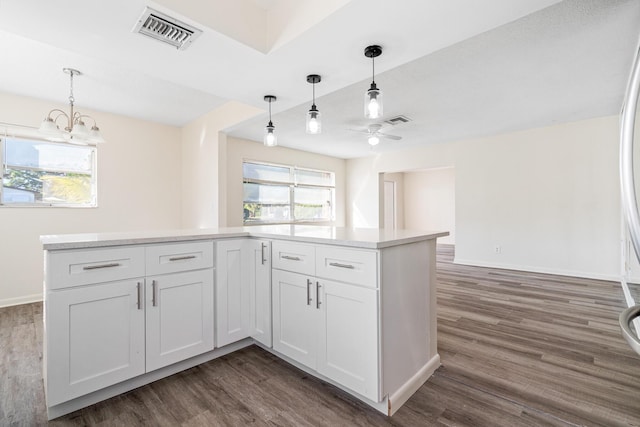 kitchen featuring pendant lighting, white cabinets, plenty of natural light, ceiling fan with notable chandelier, and dark hardwood / wood-style floors