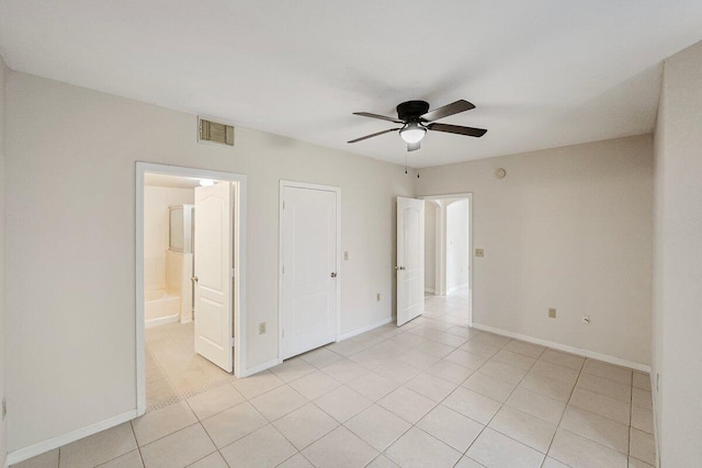 unfurnished bedroom featuring ceiling fan, light tile patterned flooring, and connected bathroom