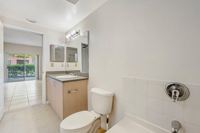 bathroom featuring tile patterned floors, vanity, a textured ceiling, and toilet