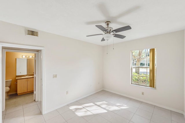 tiled spare room featuring ceiling fan and sink