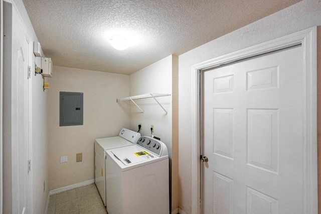 washroom with electric panel, washer and clothes dryer, and a textured ceiling