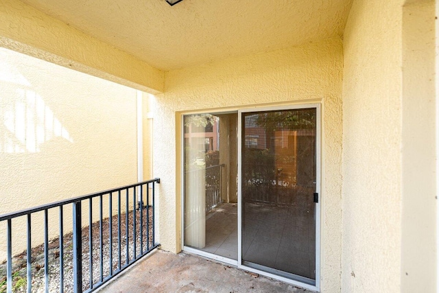 view of exterior entry with a balcony