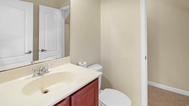 bathroom with vanity, tile patterned flooring, and toilet