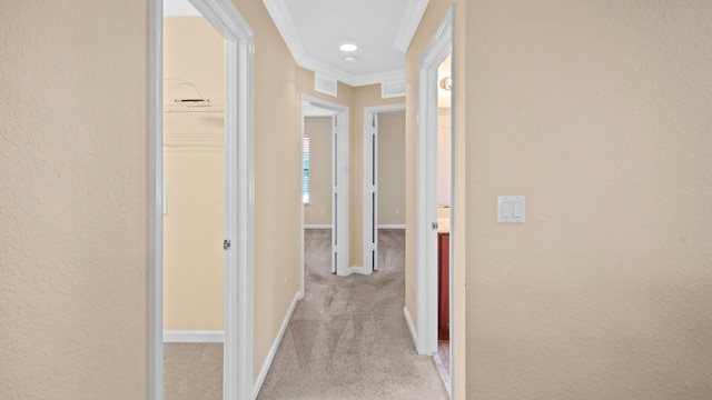 corridor featuring ornamental molding and light carpet