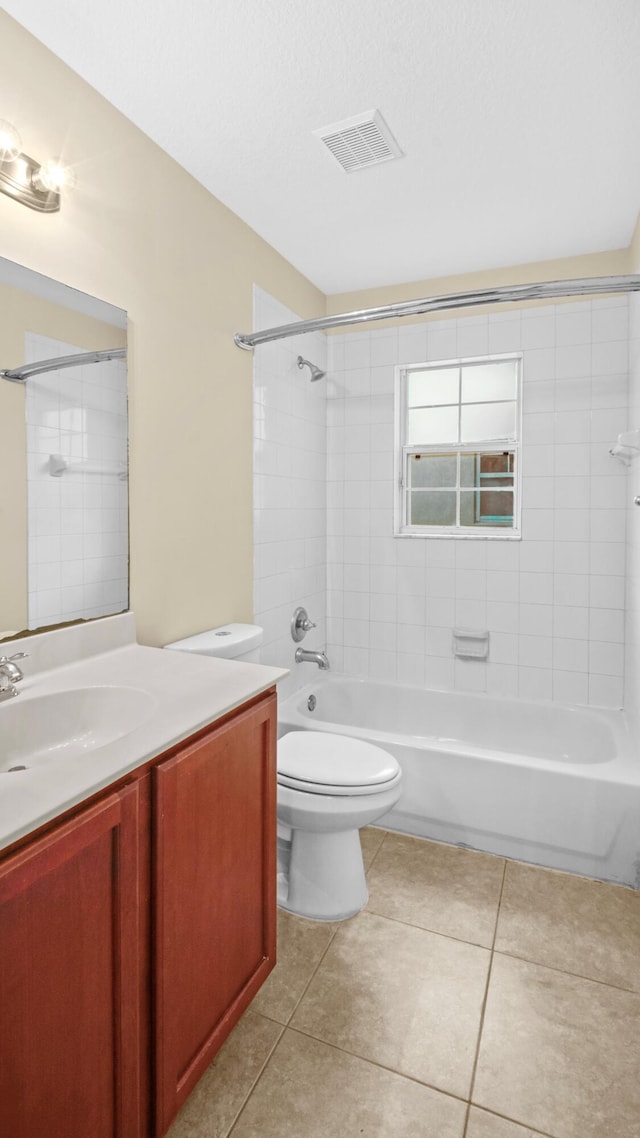 full bathroom featuring tile patterned flooring, vanity, tiled shower / bath combo, and toilet