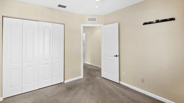 unfurnished bedroom with light colored carpet and a closet