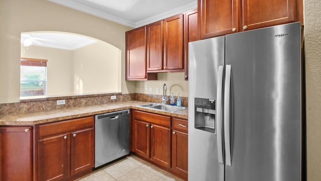 kitchen with sink, light tile patterned floors, ornamental molding, ceiling fan, and stainless steel appliances