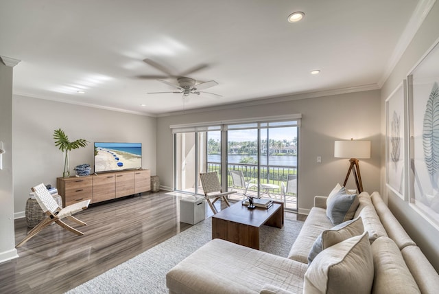 living room with hardwood / wood-style flooring, ceiling fan, and ornamental molding