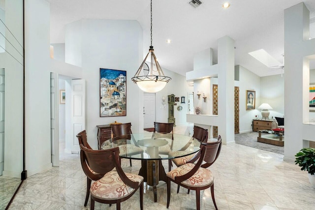 dining area featuring a skylight, high vaulted ceiling, and ceiling fan