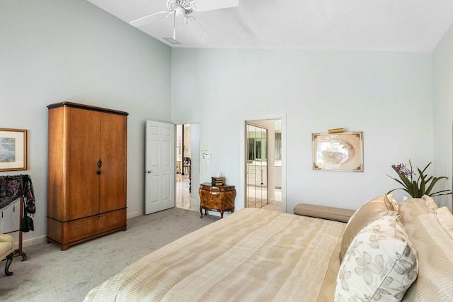 bedroom with ceiling fan, light carpet, high vaulted ceiling, and ensuite bath