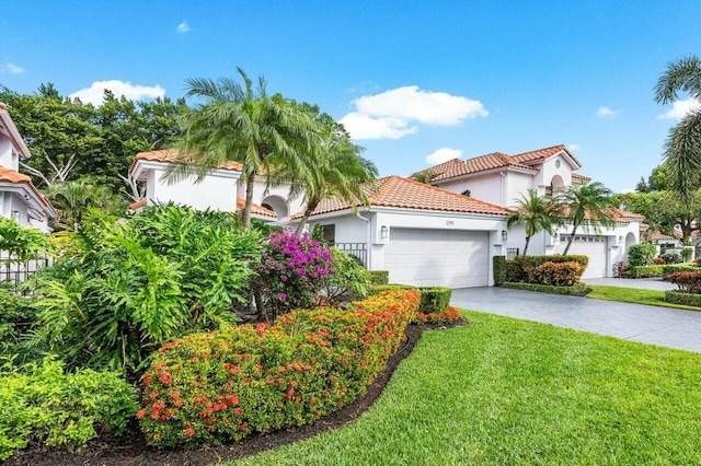 mediterranean / spanish house with a garage and a front lawn