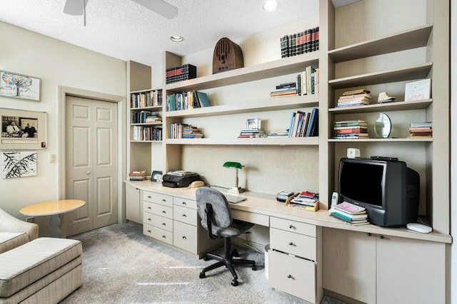 office area featuring ceiling fan, light colored carpet, and a textured ceiling