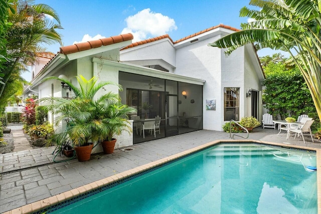 rear view of property featuring a sunroom, ceiling fan, and a patio