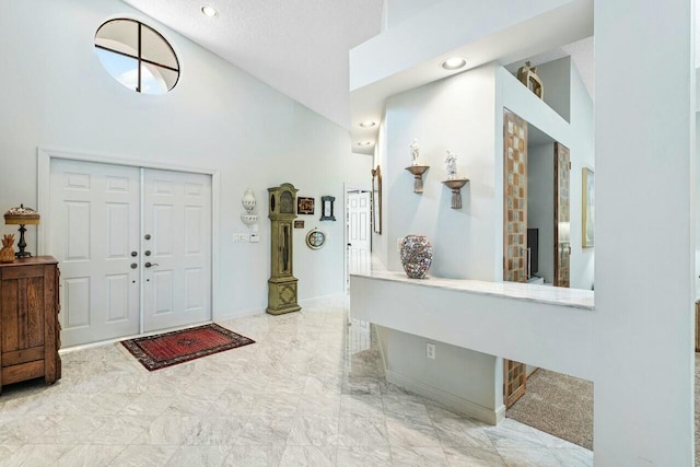 foyer entrance featuring high vaulted ceiling