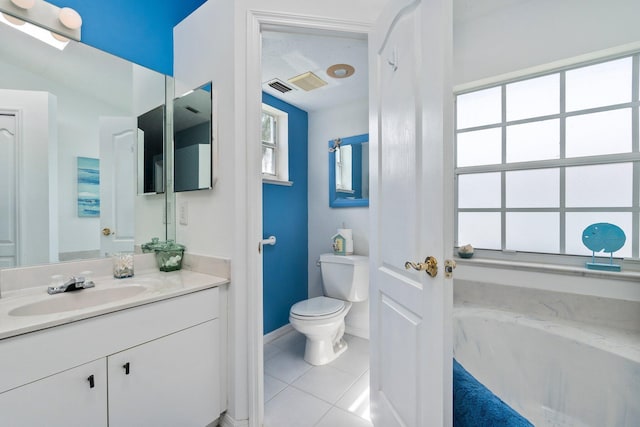 bathroom featuring tile patterned floors, vanity, a bath, and toilet