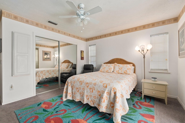 bedroom with ceiling fan, a closet, dark carpet, and a textured ceiling