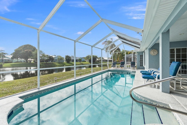 view of swimming pool with a patio, a water view, glass enclosure, and a lawn