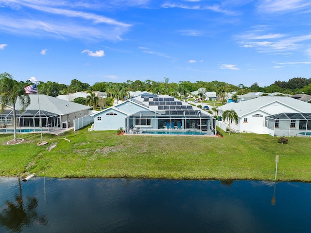 rear view of property with a yard, a water view, and glass enclosure