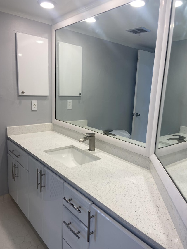 bathroom with tile patterned flooring, vanity, and toilet