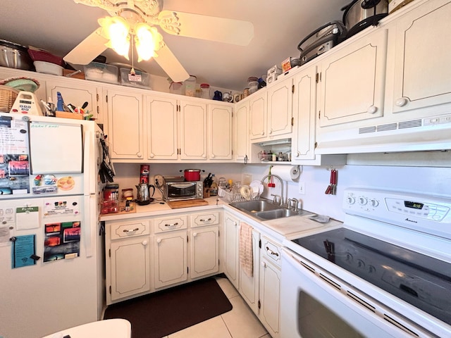 kitchen with white appliances, ceiling fan, sink, light tile patterned floors, and white cabinetry