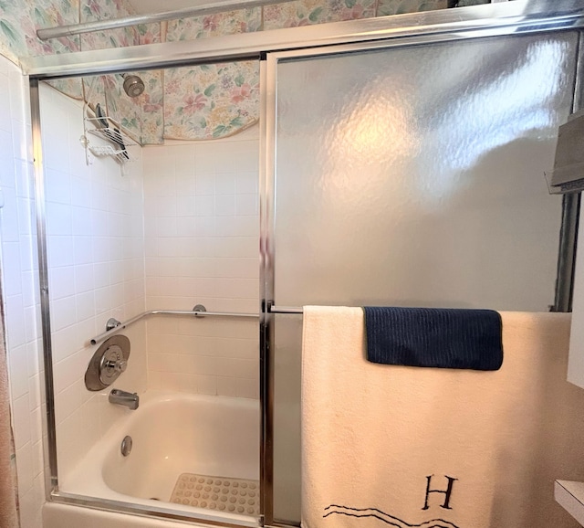 bathroom featuring combined bath / shower with glass door