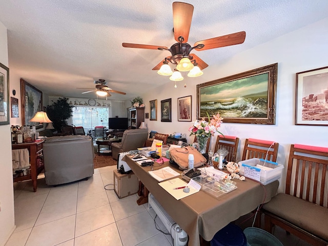 dining room with ceiling fan, light tile patterned flooring, and a textured ceiling