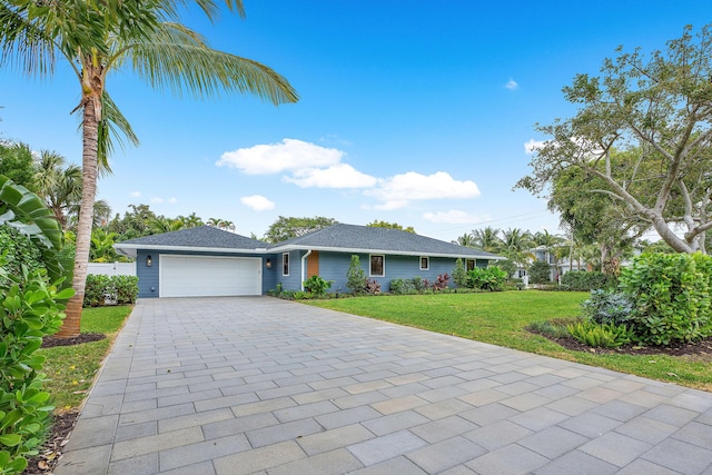 ranch-style house featuring a garage and a front lawn